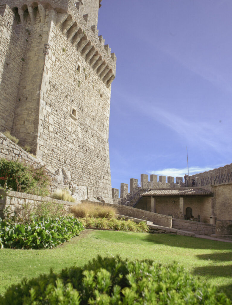 Close view of Guaita Fortress stone tower and defensive walls with battlements and grassy foreground, showcasing medieval architecture explored during 2 days in San Marino.