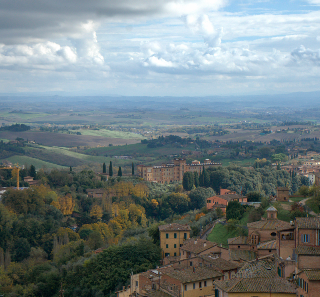 Panoramic view over Siena from the Facciatone viewpoint with rolling hills and terracotta buildings stretching into the distance. This hidden gem is a must see stop on a 2 days in Siena itinerary.