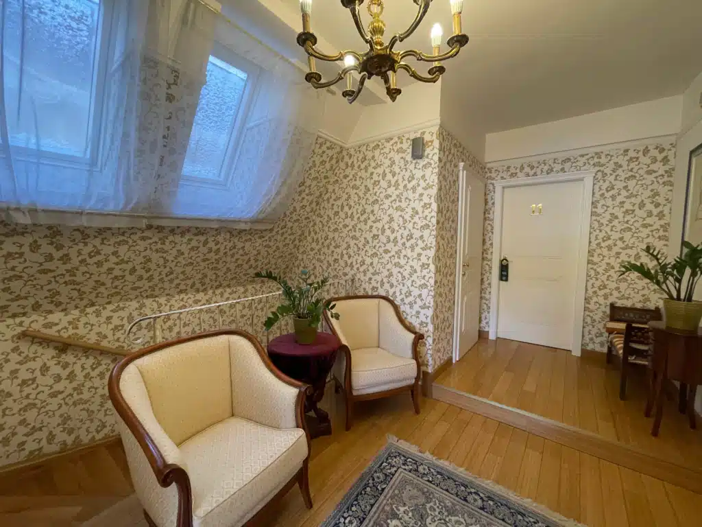 Allegro Hotel Ljubljana third floor sitting area with vintage armchairs, chandelier, and guest room 11 entrance