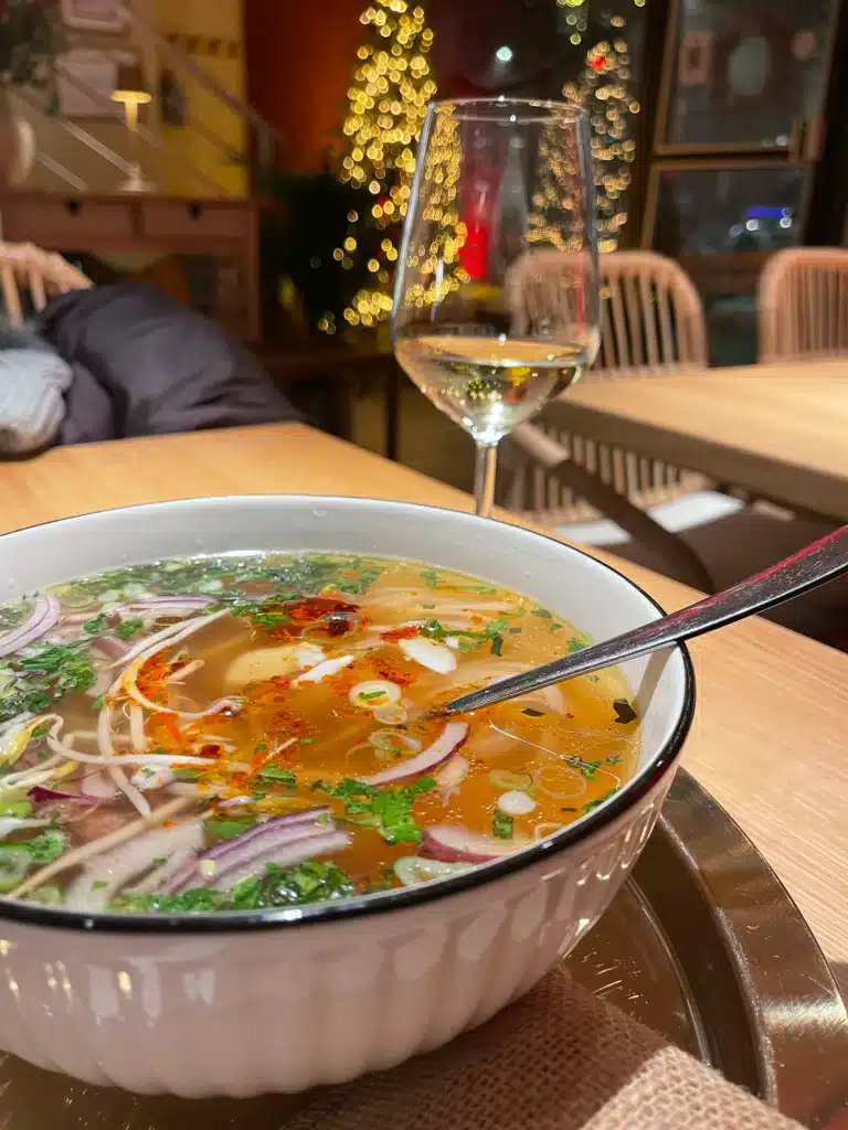 Vietnamese pho with bean sprouts, herbs, and chili oil paired with Slovenian white wine at Basa in Ljubljana