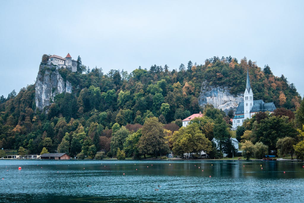 Picturesque view of Bled Castle and St. Martin's Church with lush greenery in Slovenia.