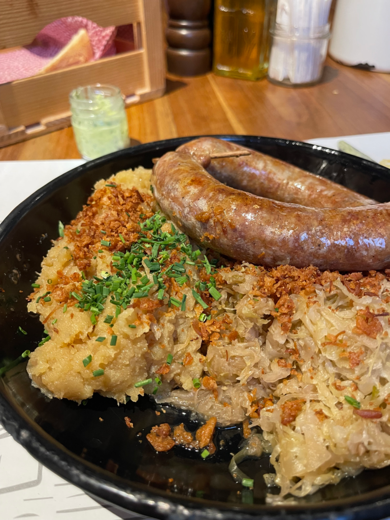Pečenica sausage with mashed potatoes and sauerkraut at Slovenska Hiša Figovec in Ljubljana