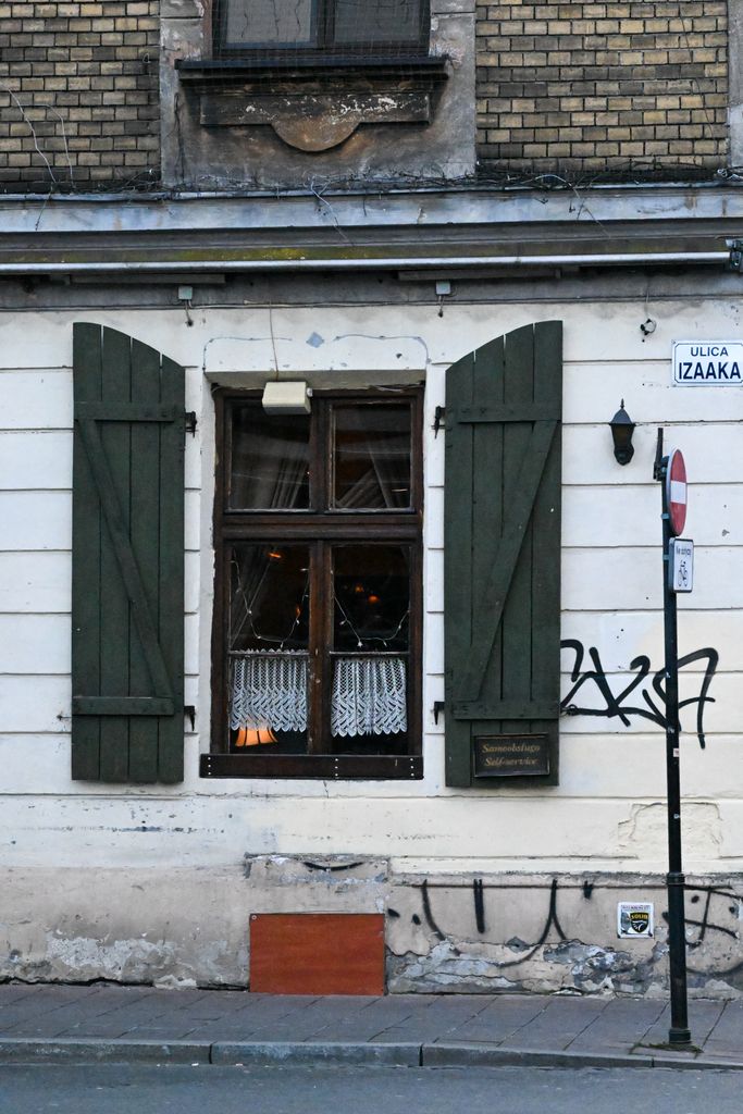 Historic building facade with window and shutters in Krakow, Poland.