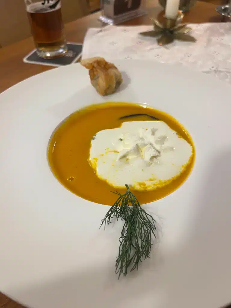 Creamy pumpkin soup with dollop of whipped cream and small fried dumpling, starter course at Gasthof Meindl near Lake Constance