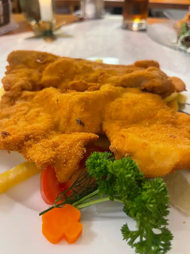 Golden breaded schnitzel with fries, tomato, and parsley garnish at Gasthof Meindl restaurant, Lake Constance Christmas itinerary dinner stop