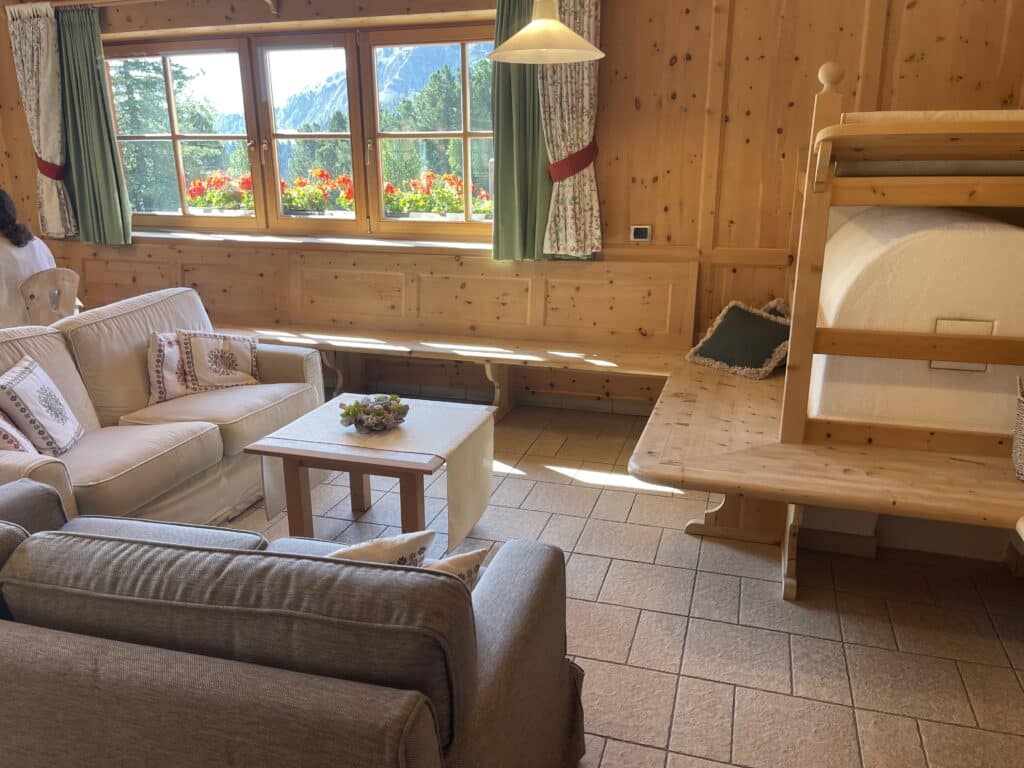 Cozy wood-paneled lounge seating area with mountain views at Ütia de Börz