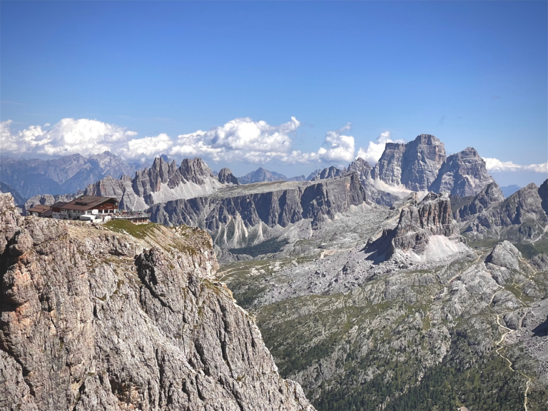 Rifugio Lagazuoi perched on a cliff edge with the Dolomites mountain range behind it