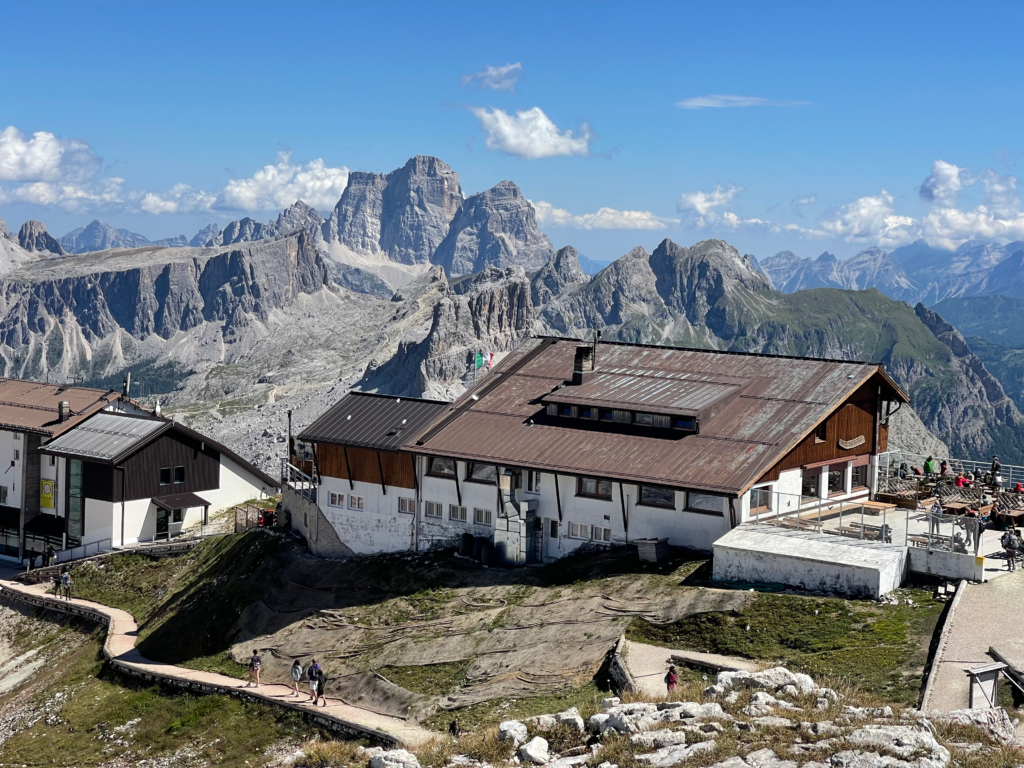 The back of the Rifugio Lagazuoi in the summertime with people walking around up top