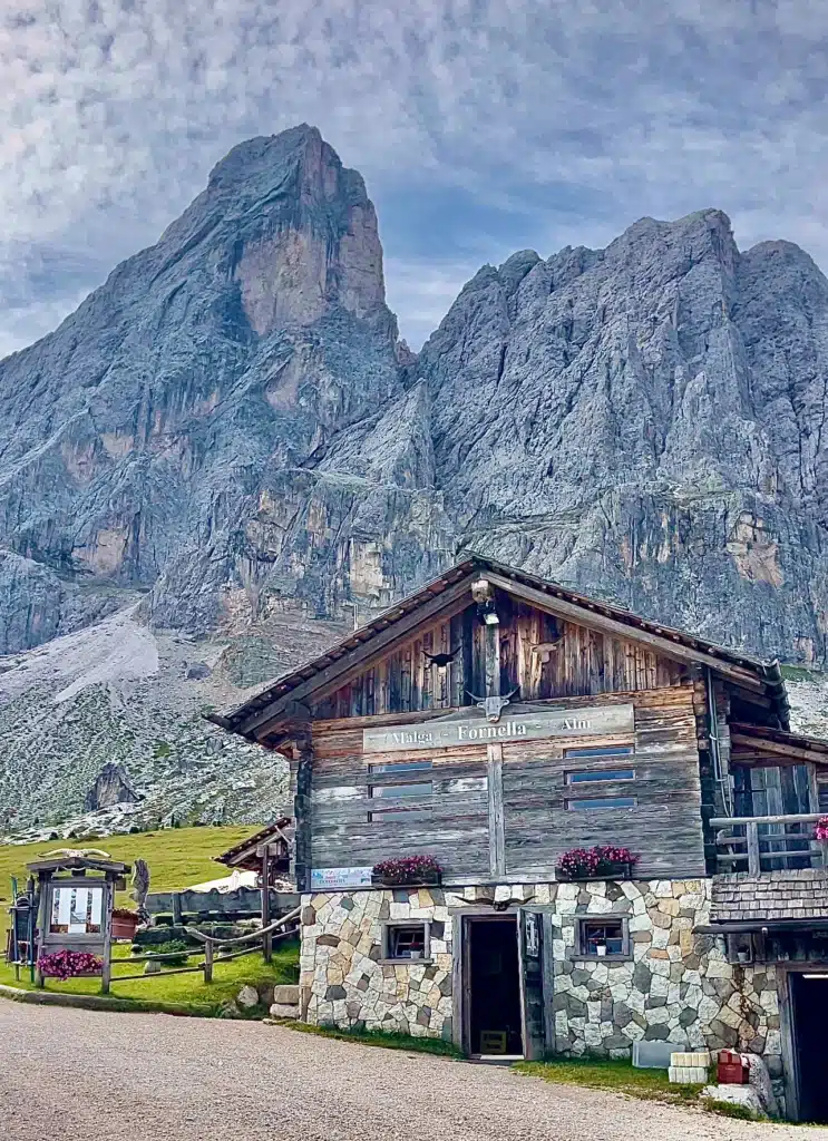 The trailhead hut at Malga Fornella, with Sass de Putia's twin summits already daring you to keep looking up.