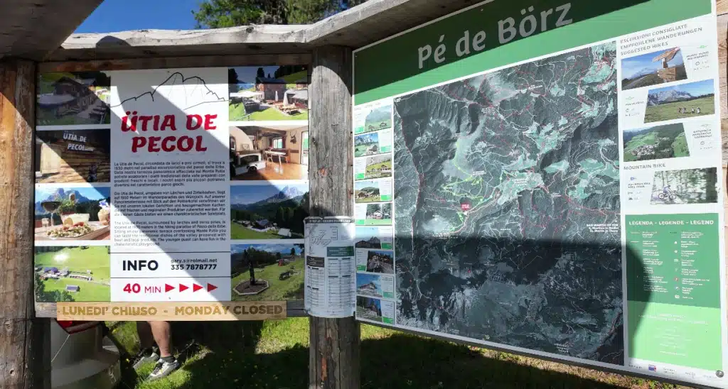 : Trailhead info board at Pè de Börz showing the route to Ütia de Pecol and suggested hikes