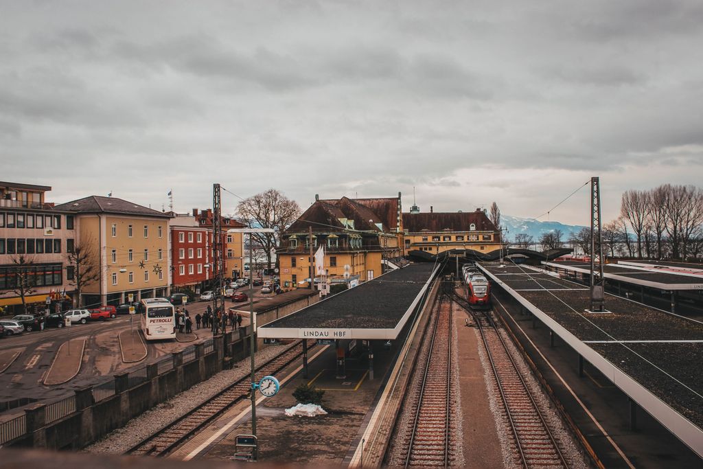 View of Lindau Hbf train station with platforms and trains under winter skies.