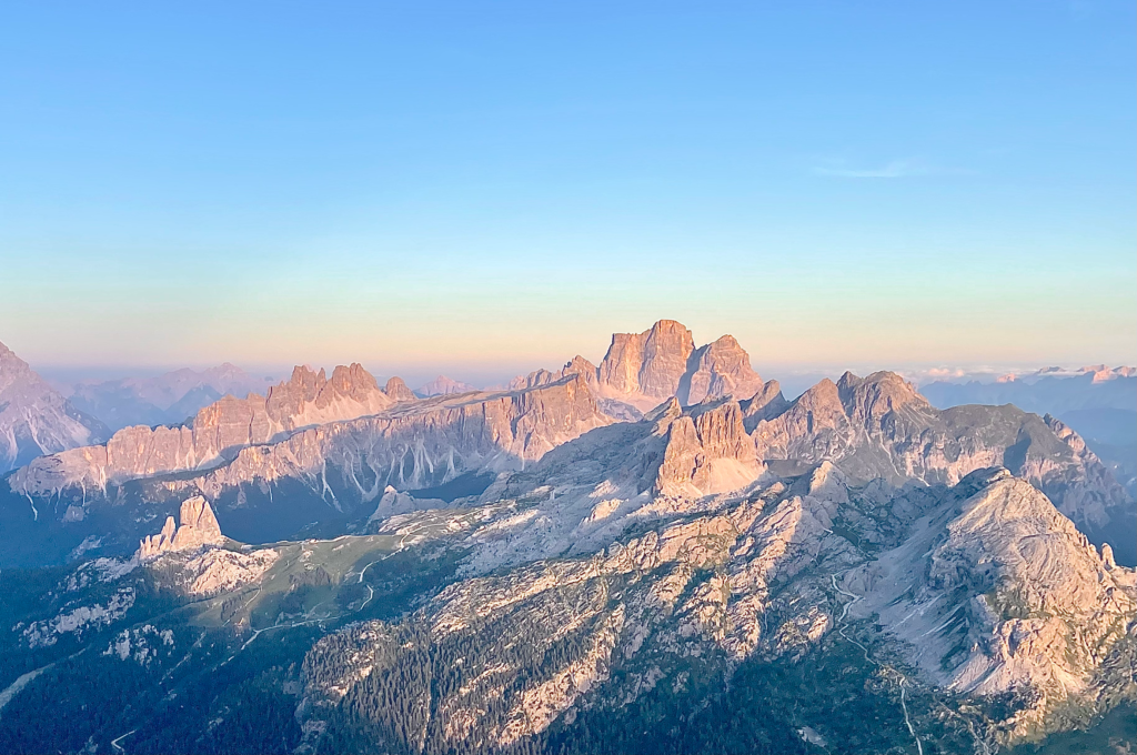 Dolomites mountain range glowing pink and orange at sunset