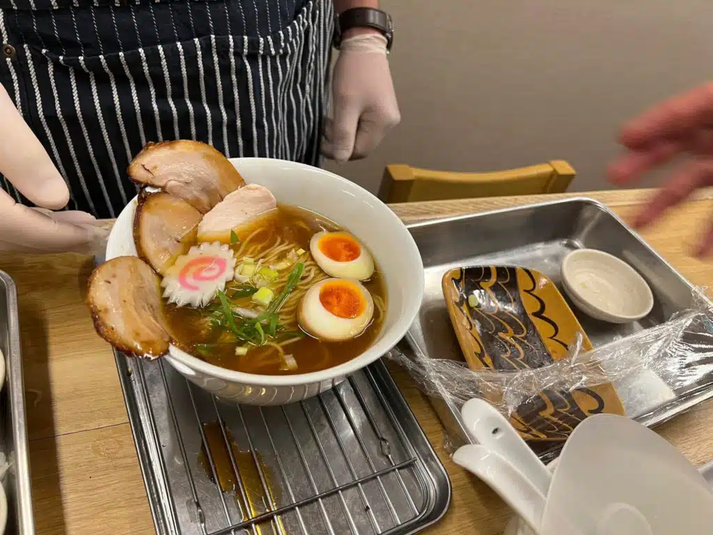 Finished bowl of shoyu ramen with chashu, ajitama egg and narutomaki made at a ramen cooking class in Osaka
