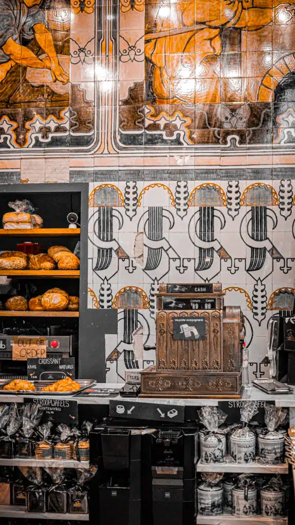 Vintage tiled interior and brass cash register at a historic Amsterdam bakery selling stroopwafels