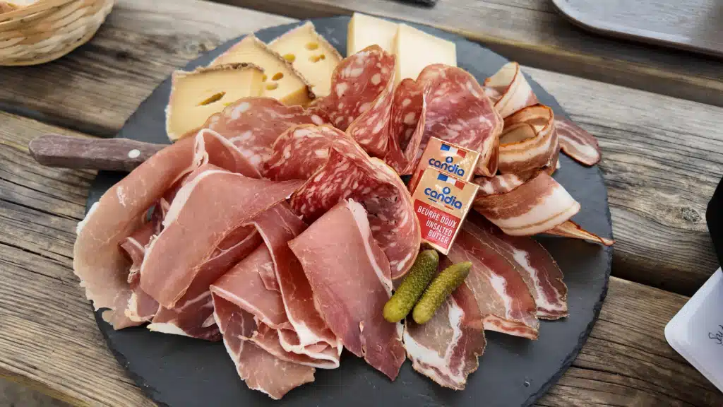 Savoie charcuterie board with cured ham, saucisson, alpine cheese and cornichons at Refuge de la Glière on the Tour du Vallaisonnay