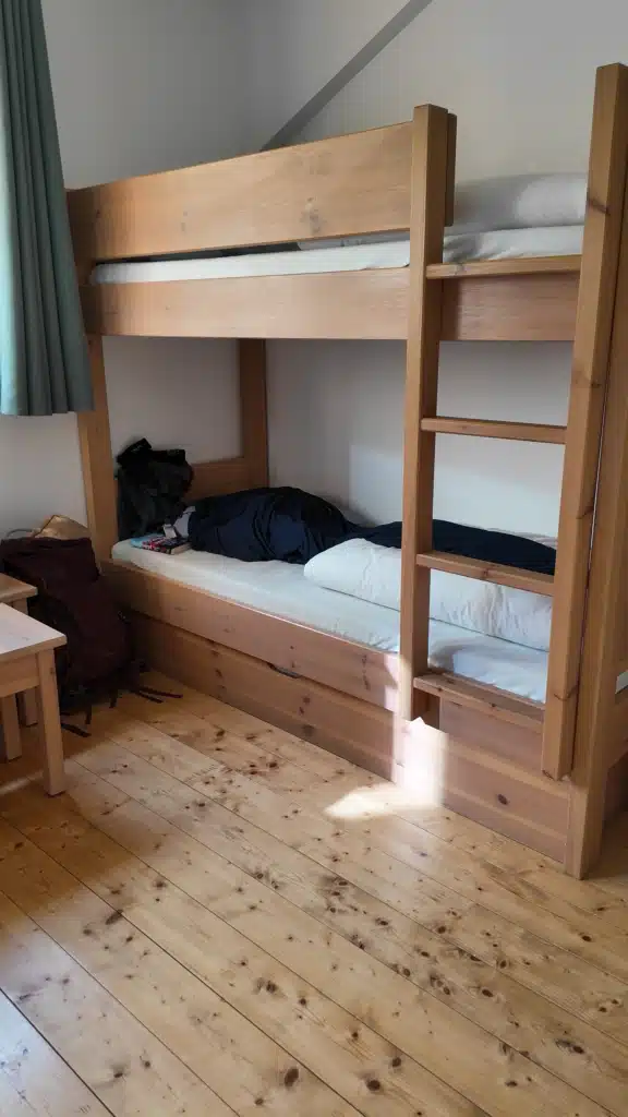 Wooden bunk beds in a dormitory room at Refuge de la Glière, hut-to-hut accommodation on the Tour du Vallaisonnay in Vanoise National Park