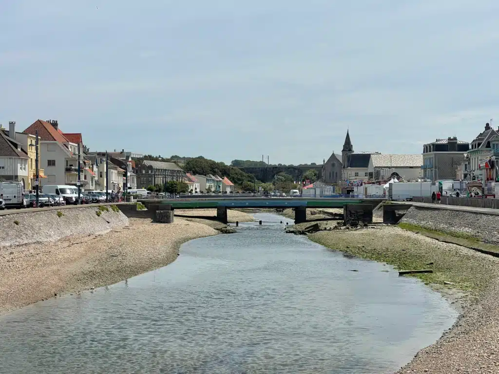The Wimereux river at low tide with the railway viaduct and church in the background, Wimereux, France